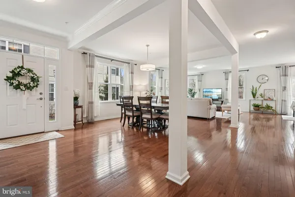 a view of a a dining room and livingroom with furniture wooden floor a chandelier