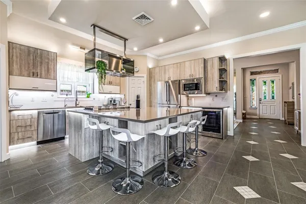 a kitchen with stainless steel appliances a stove a sink dishwasher a oven with a dining table and chairs