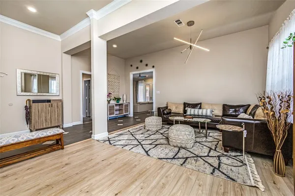 a living room with furniture a wooden floor and potted plant