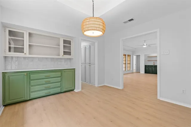 a view of an empty room with a window and kitchen