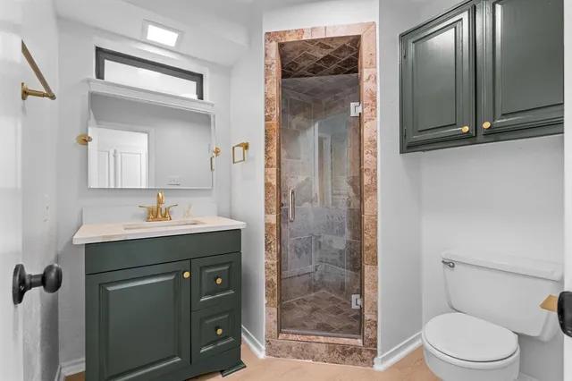 a bathroom with a sink a toilet a mirror and shower