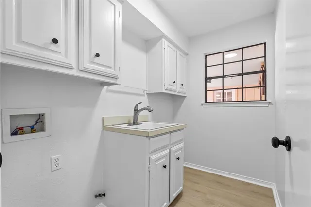 a kitchen with white cabinets and sink