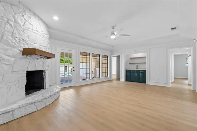 a view of an empty room with a fireplace and a window