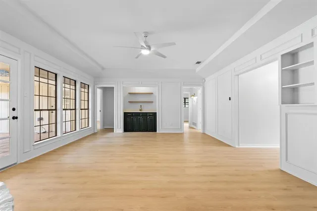 a view of an empty room with a window and a kitchen