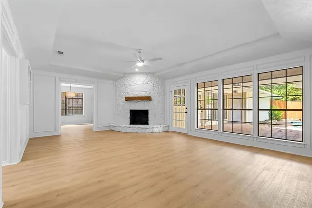 a view of an empty room with a window and fireplace