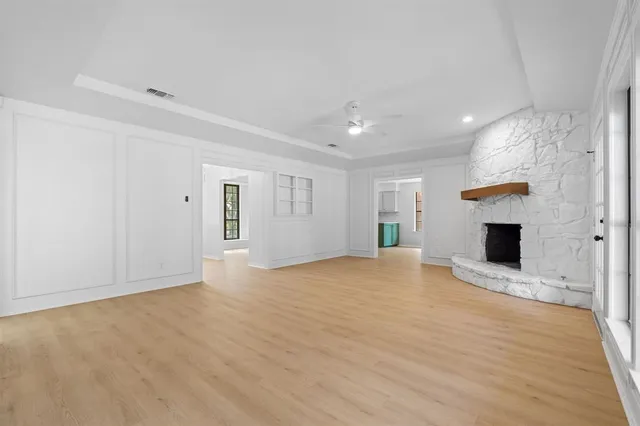 a view of empty room with wooden floor and fireplace