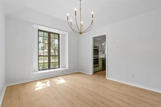 an empty room with windows and chandelier