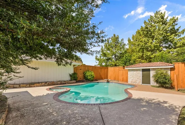 a front view of a house with garden and trees