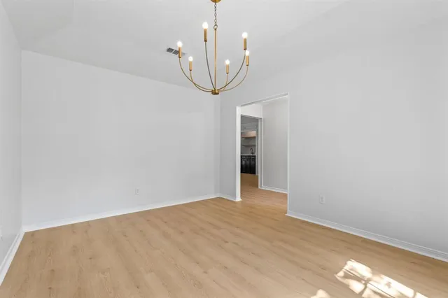 a view of a room with wooden floor and ceiling fan