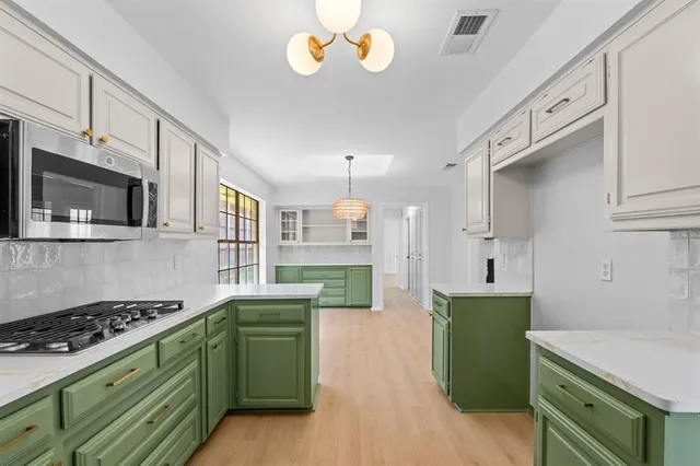a kitchen with cabinets a stove and a wooden floors