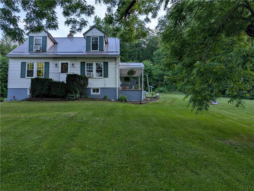 205 Woods Road Ligonier, PA 15658 - Photo 26 of 32 a front view of a house with a garden and trees