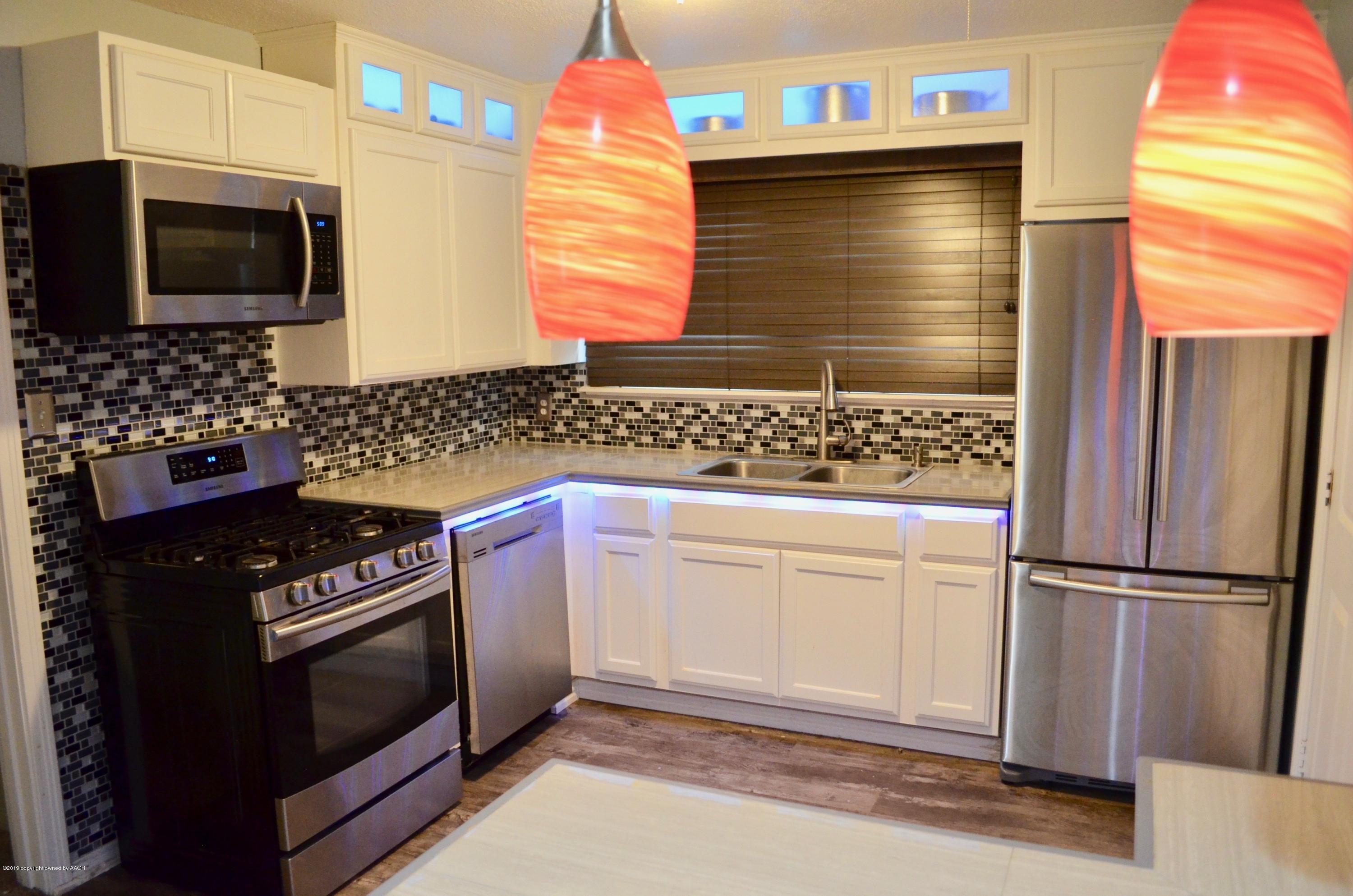 4100 Cline Road Amarillo, TX 79110 - Photo 3 of 10 a kitchen with granite countertop cabinets stainless steel appliances and wooden floor