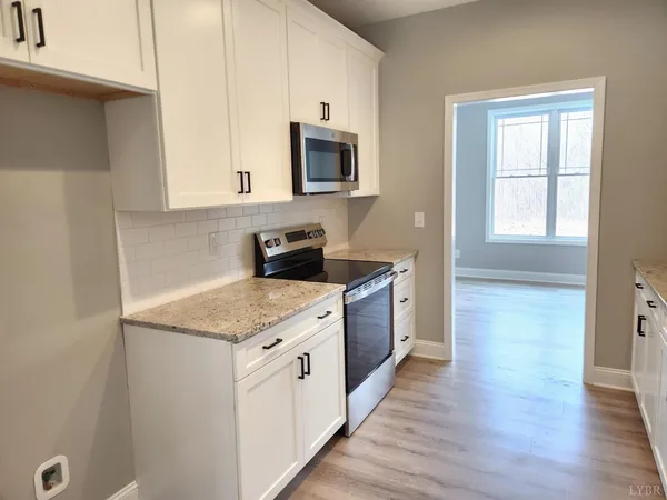 a kitchen with stainless steel appliances granite countertop a sink stove and microwave