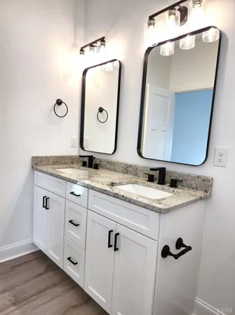 a bathroom with a granite countertop sink and mirror
