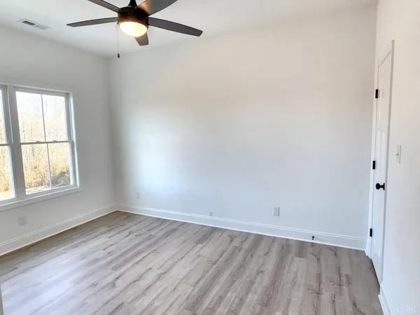 an empty room with a window and a ceiling fan