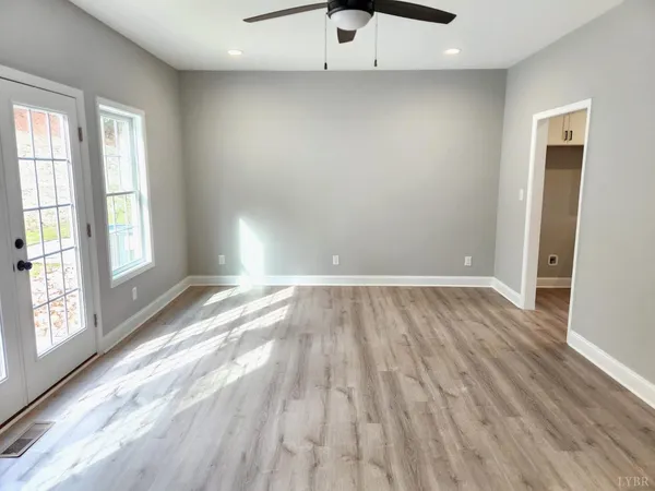an empty room with wooden floor and windows