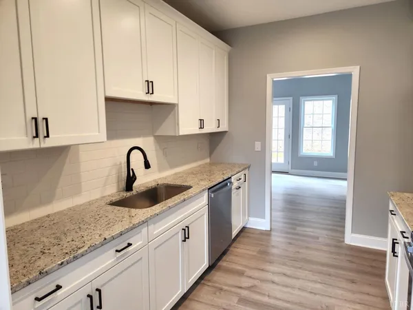 a kitchen with granite countertop a sink stainless steel appliances and cabinets