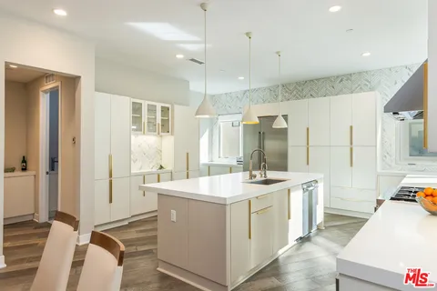 a room with a sink a counter and a view of living room
