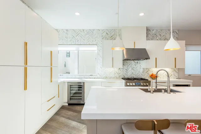 a kitchen with kitchen island granite countertop a sink a stove and a refrigerator