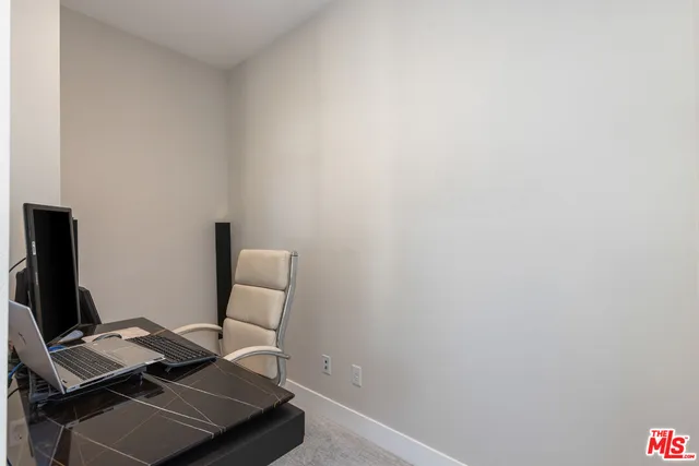 a view of a workspace with furniture and a window