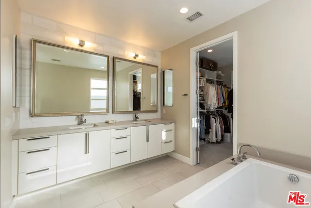 a en suite bathroom with a double vanity sink and a mirror