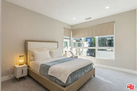 a bedroom with a large bed and a large window