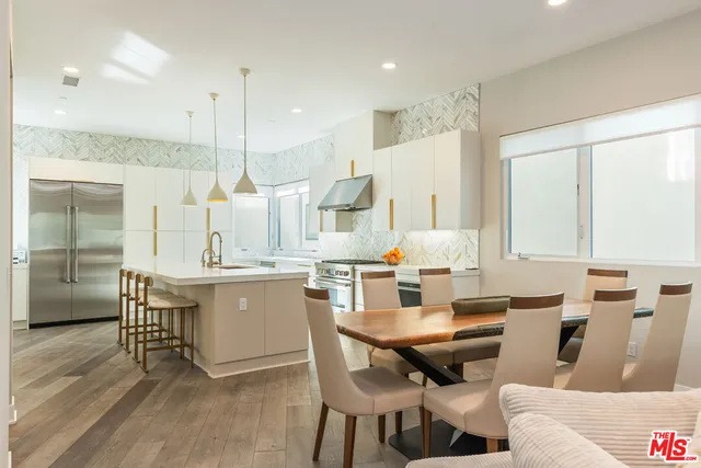 a kitchen with a dining table chairs and white cabinets