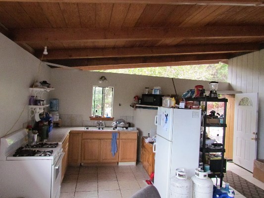 88-2512 Milolii Road Captain Cook, HI 96704 - Photo 7 of 24 a kitchen that has a sink a stove and a refrigerator