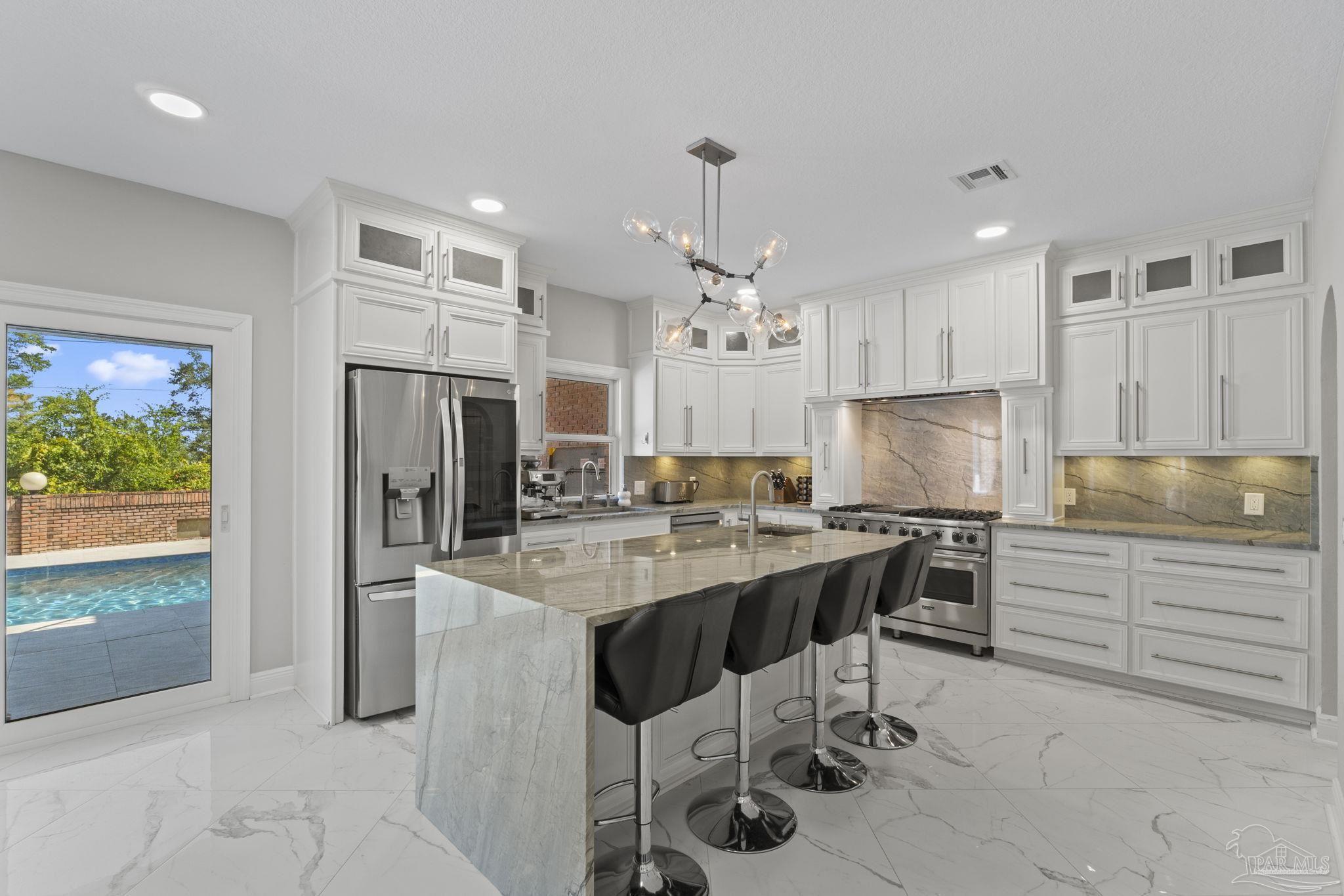 4818 Rosemont Place Pensacola, FL 32514 - Photo 22 of 69 a kitchen with stainless steel appliances kitchen island granite countertop a refrigerator and a stove top oven
