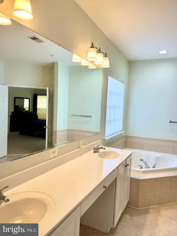 a bathroom with a tub sink and mirror