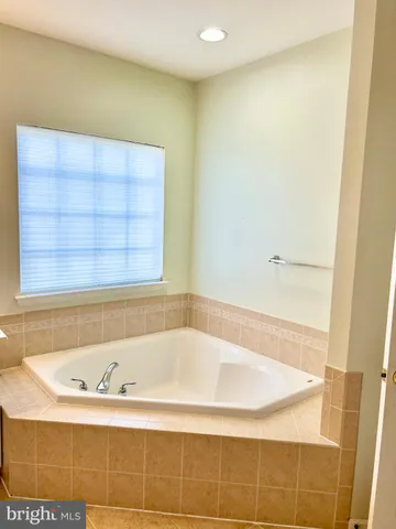 a bathroom with bathtub and window