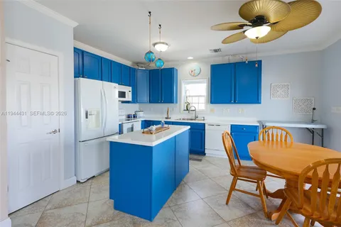 a kitchen with stainless steel appliances a refrigerator a stove a sink dishwasher a dining table and chairs with wooden floor