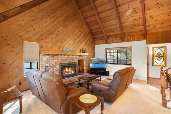 a living room with furniture a fireplace and a floor to ceiling window