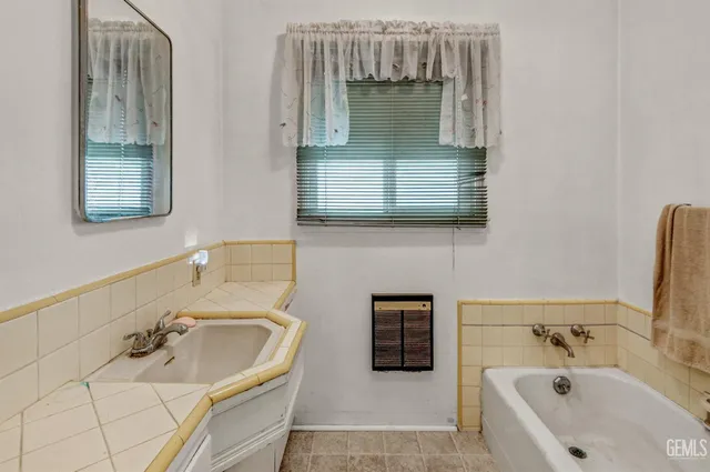 a bathroom with a tub sink and mirror