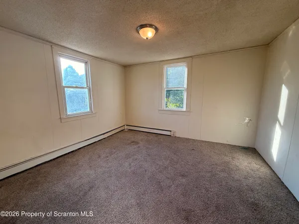 an empty room with windows and closet