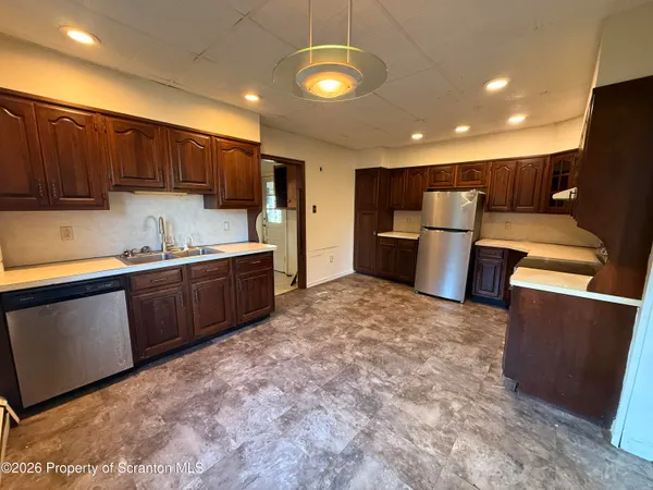 a kitchen with stainless steel appliances granite countertop a sink refrigerator and cabinets