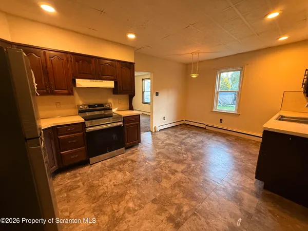 a kitchen with stainless steel appliances a refrigerator and a stove top oven
