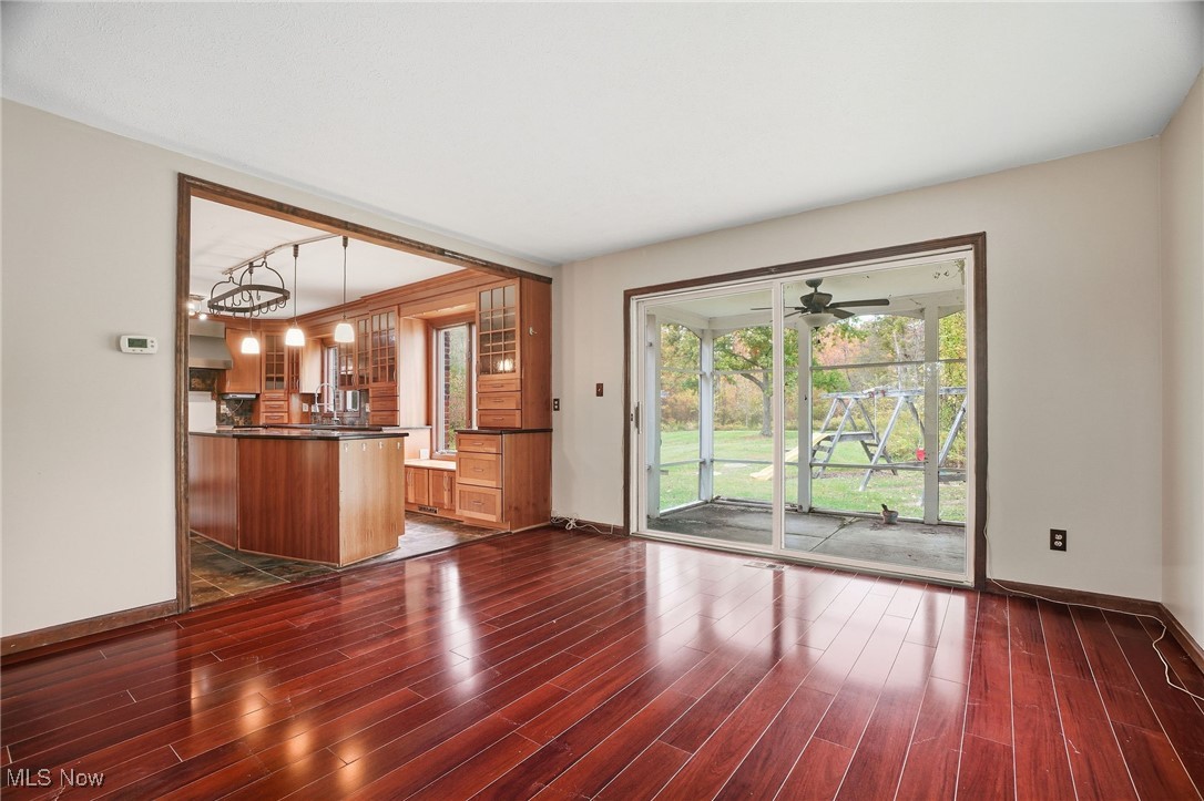 11710 Butternut Road Chardon, OH 44024 - Photo 12 of 48 Unfurnished living room featuring dark wood-style flooring and ceiling fan & sliding doors