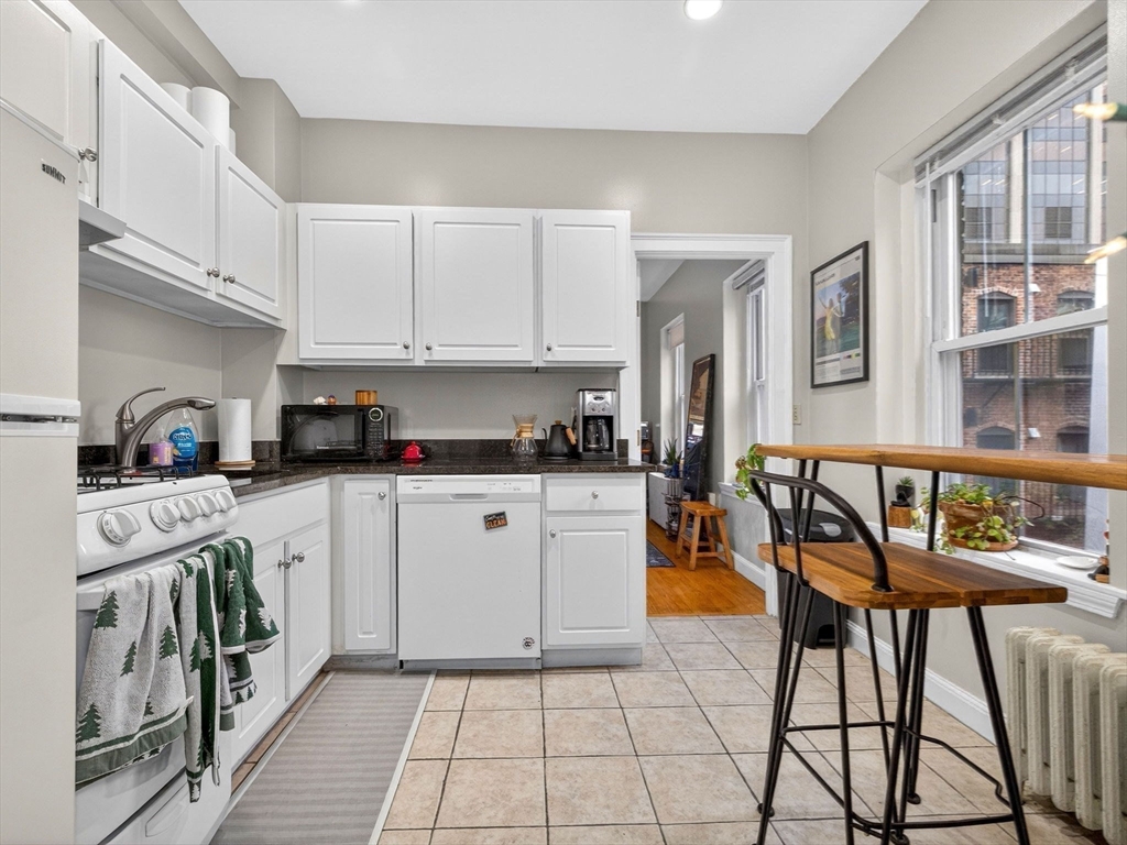 52 Temple Street Boston, MA 02114 - Photo 13 of 34 a kitchen with stainless steel appliances granite countertop a stove and white cabinets