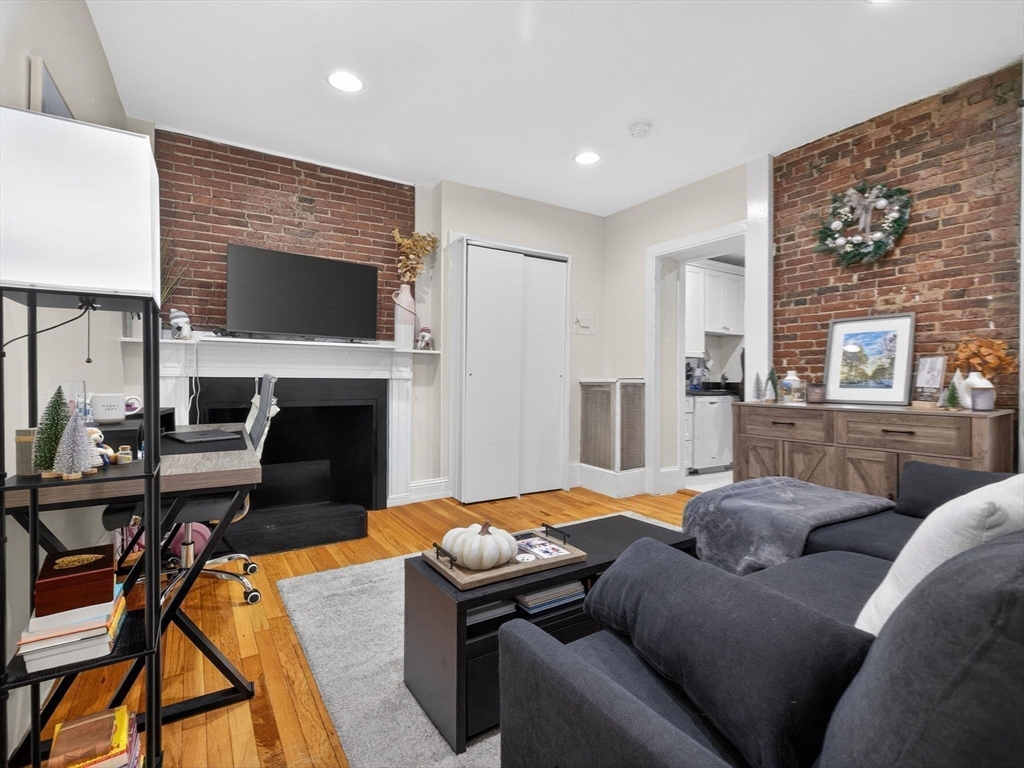 52 Temple Street Boston, MA 02114 - Photo 16 of 34 a living room with furniture a flat screen tv and a fireplace