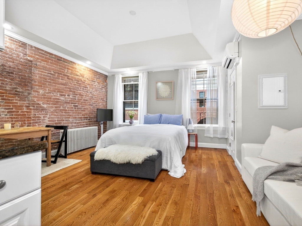 52 Temple Street Boston, MA 02114 - Photo 5 of 34 a spacious bedroom with a bed and a table