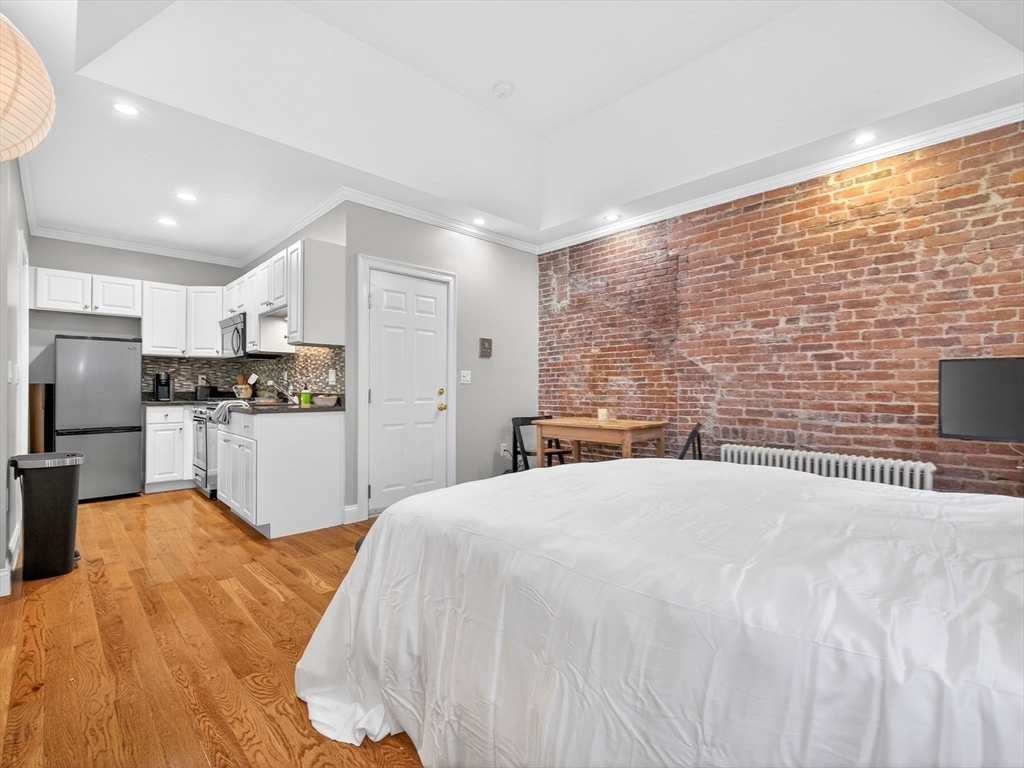 52 Temple Street Boston, MA 02114 - Photo 8 of 34 a bed room with a bed and a view of kitchen