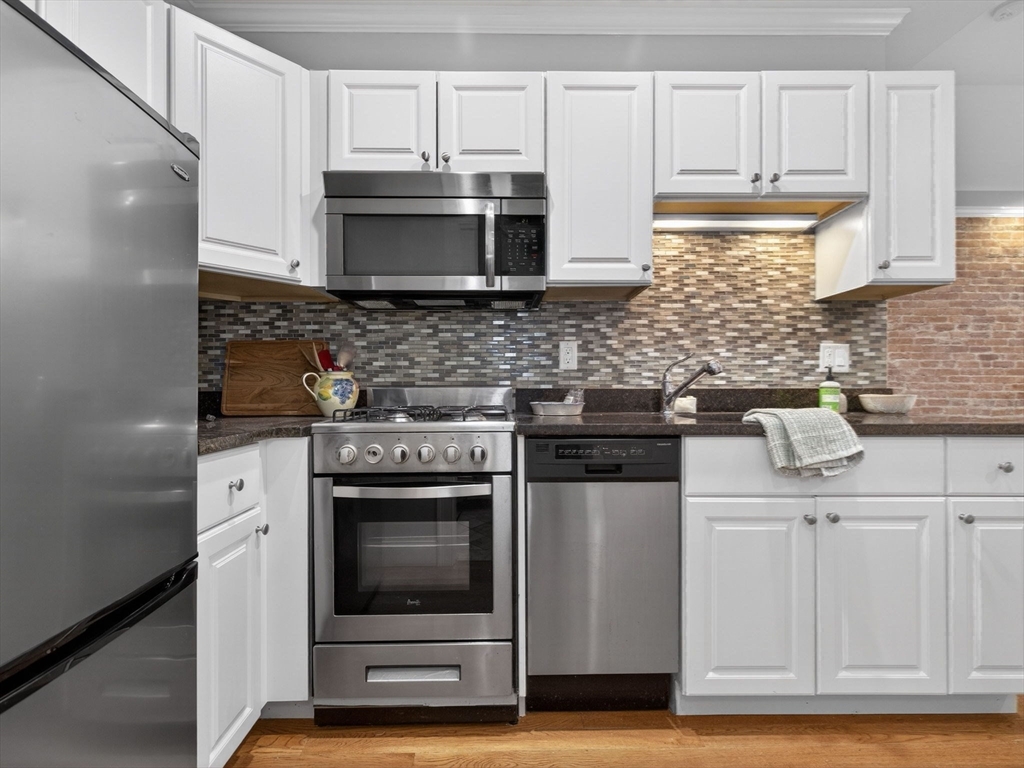 52 Temple Street Boston, MA 02114 - Photo 9 of 34 a kitchen with stainless steel appliances granite countertop a stove and a microwave