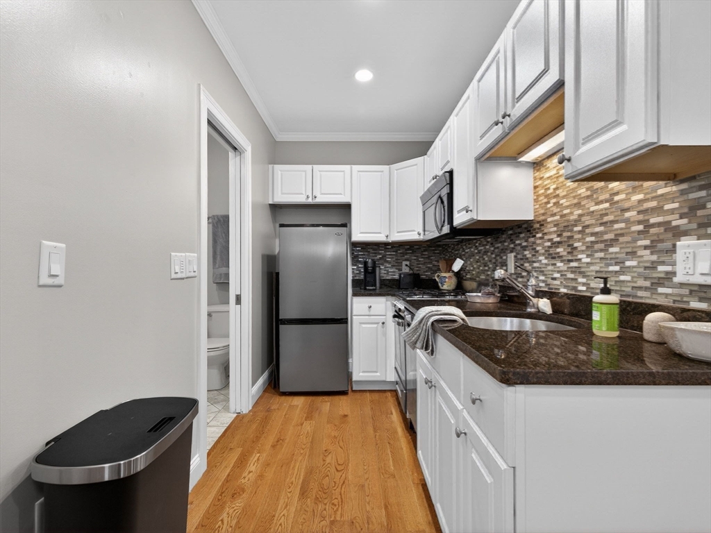 52 Temple Street Boston, MA 02114 - Photo 10 of 34 a kitchen with a refrigerator and a sink
