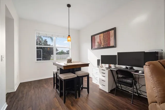 a view of a workspace with furniture and a window
