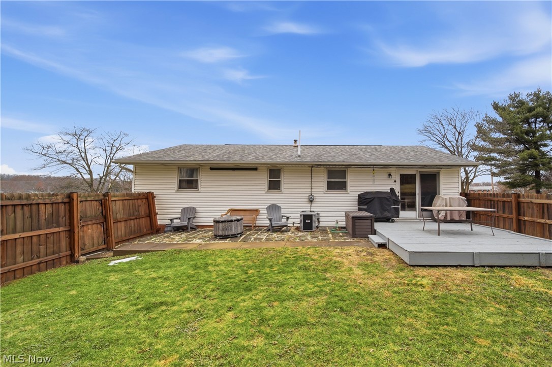 702 Perry Drive Northwest Canton, OH 44708 - Photo 2 of 46 Back of property with a fenced backyard, a patio, roof with shingles, and a wooden deck