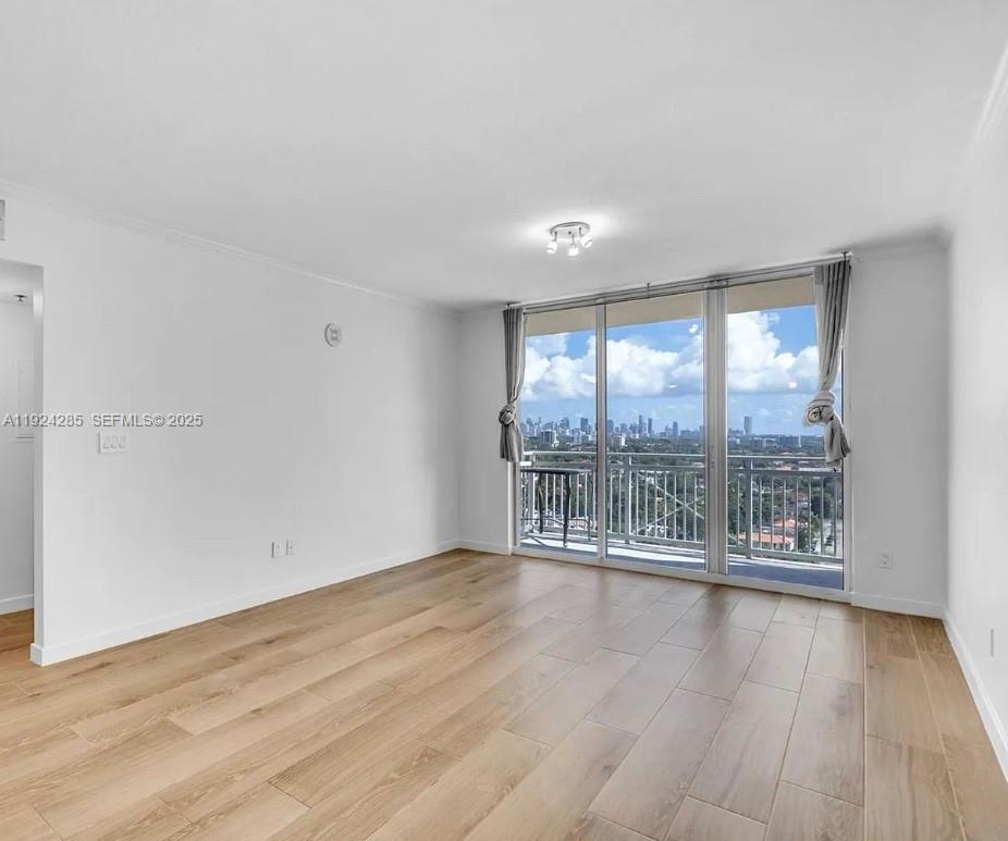 2665 Southwest 37th Avenue, Unit 1501 Miami, FL 33133 - Photo 5 of 10 wooden floor in an empty room with a window