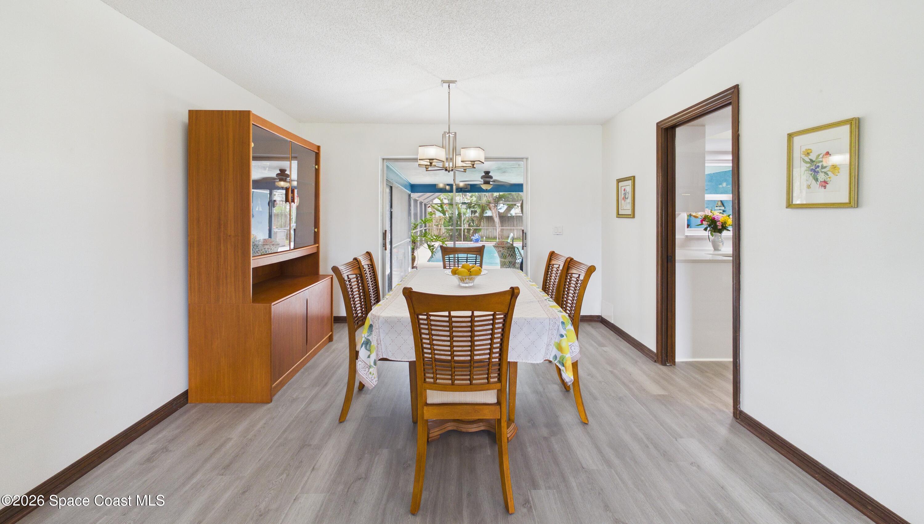 280 Coral Way West Indialantic, FL 32903 - Photo 12 of 72 a dining room with furniture a chandelier and wooden floor