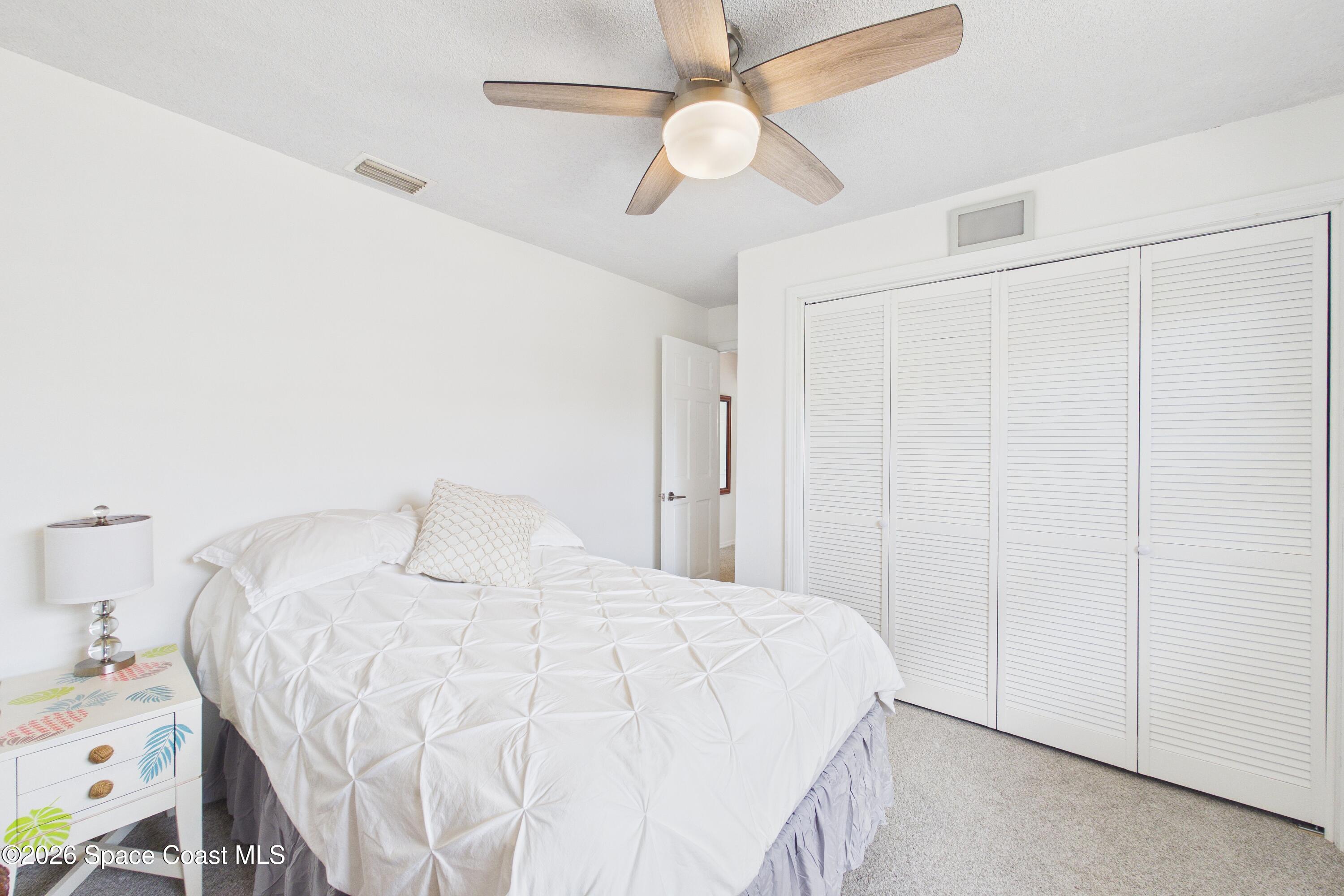 280 Coral Way West Indialantic, FL 32903 - Photo 27 of 72 a bedroom with a bed and a ceiling fan