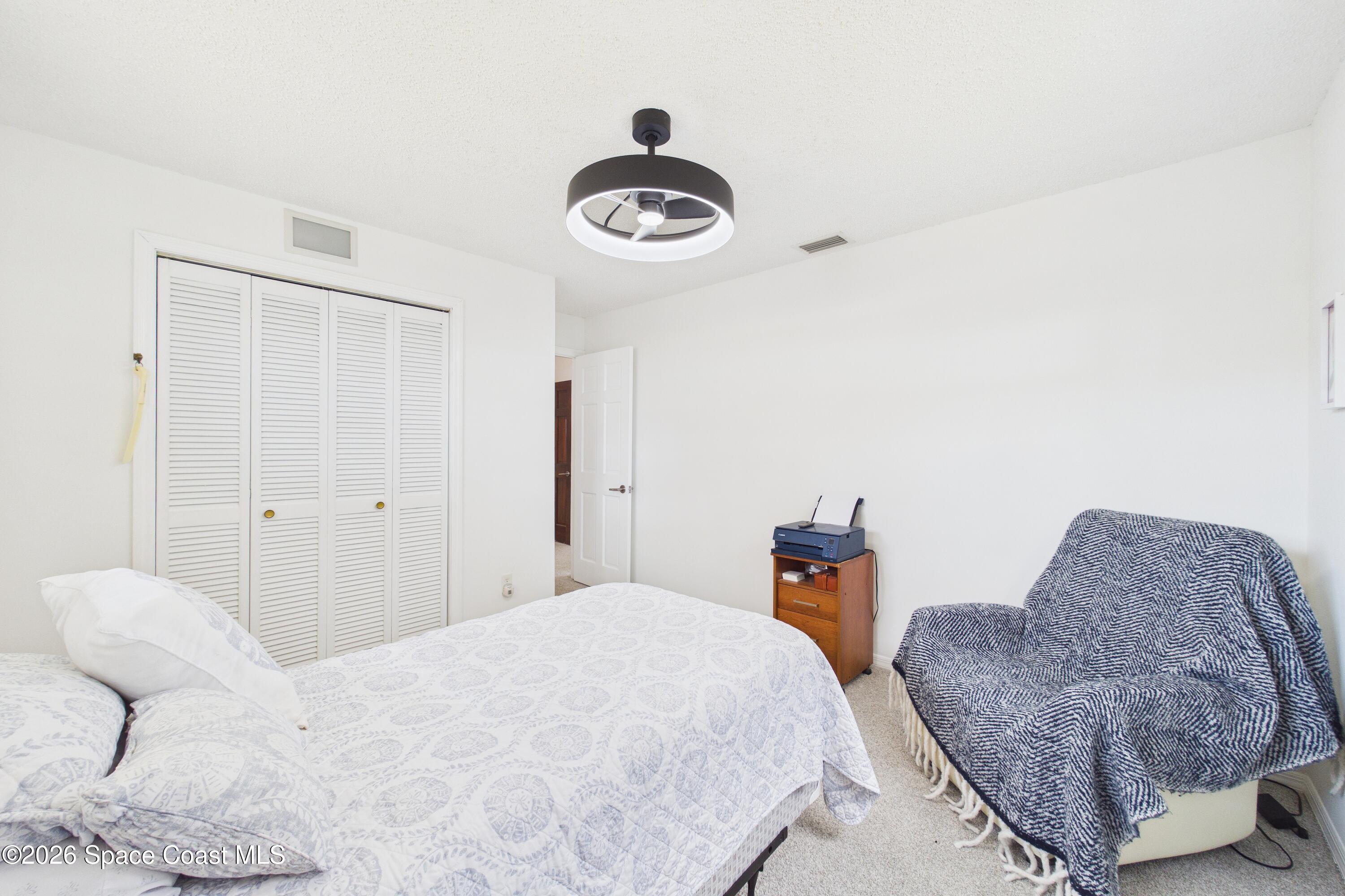 280 Coral Way West Indialantic, FL 32903 - Photo 28 of 72 a bedroom with a bed and a chandelier